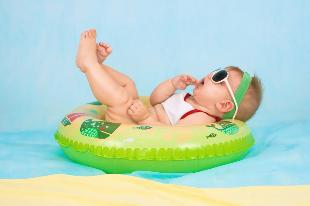 Bebé feliz con gafas de sol en un flotador